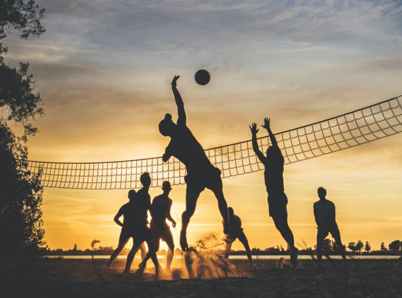 silhouette of people playing basketball during sunset