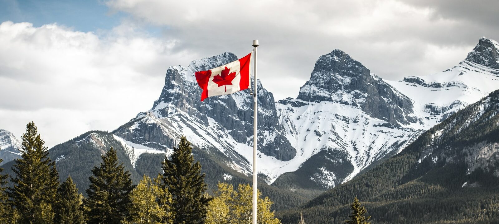 us a flag on pole near snow covered mountain